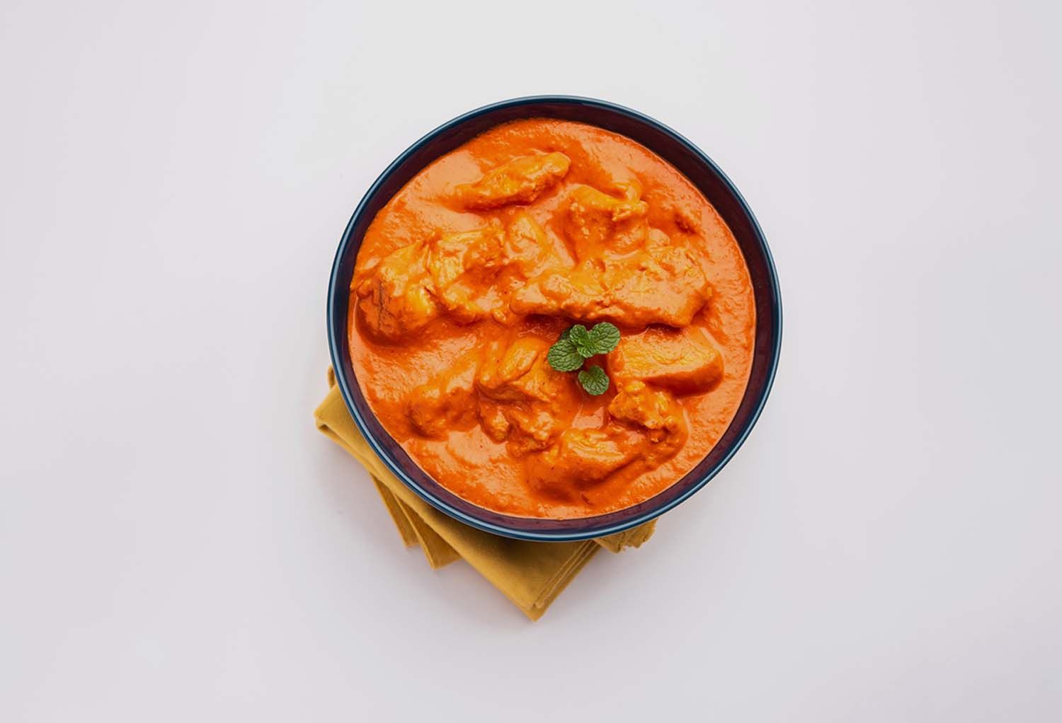 Delicious bowl of butter chicken curry is made with tender chicken pieces